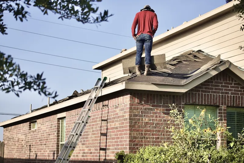 Professional roofer working on a residential roof in East Niles